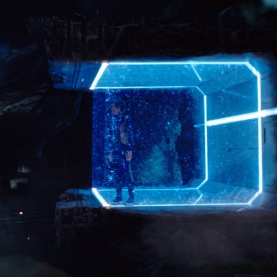 Burnham stands at the edge of a brig cell, surrounded by a blue force field. The room around the cell has been destroyed, exposing it to space.